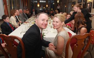 Happy wedding couple at dinner table.