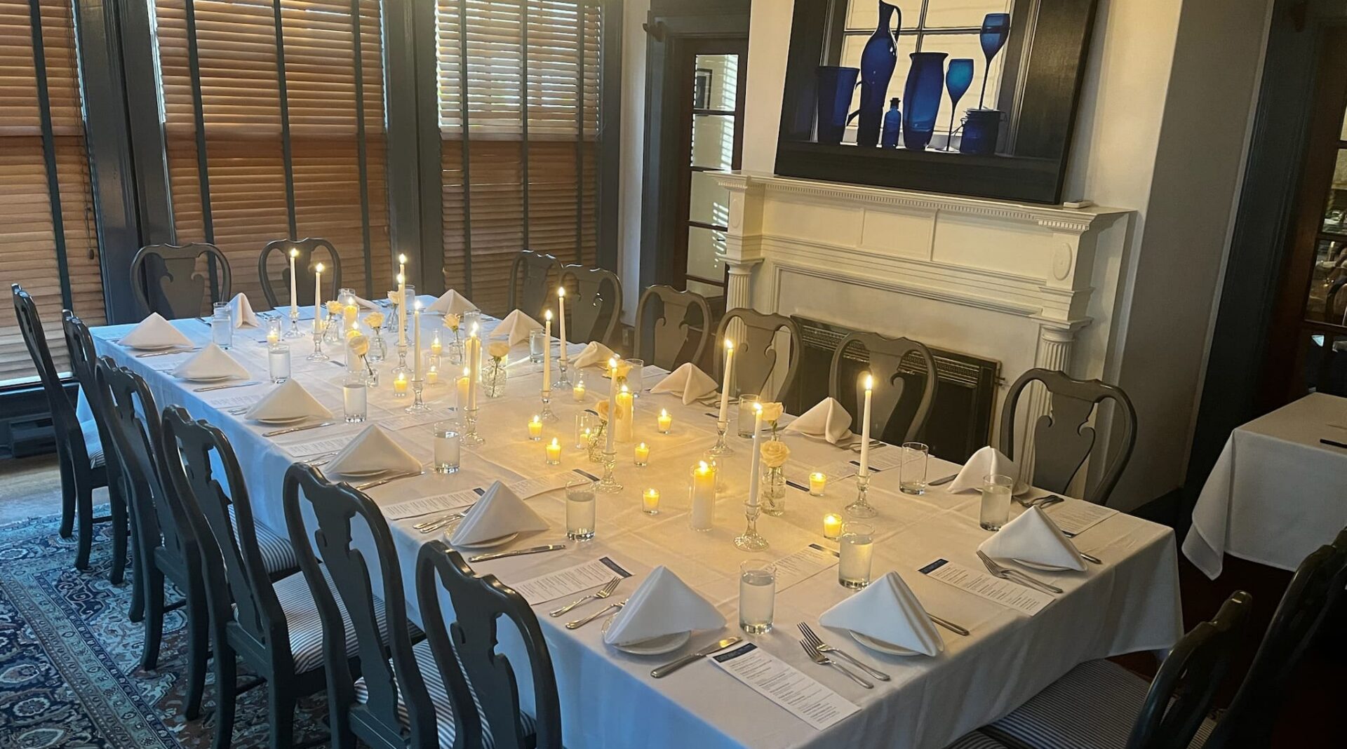 long table set with candles near fireplace